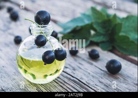 Black currant extract in a glass bottle. Medicinal tincture with black currant. Close-up. Stock Photo