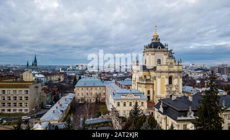 A beautiful view of the church with dark domes and yellow walls in the middle of the center of a city in Lviv. Archcathedral Cathedral of St. George Stock Photo