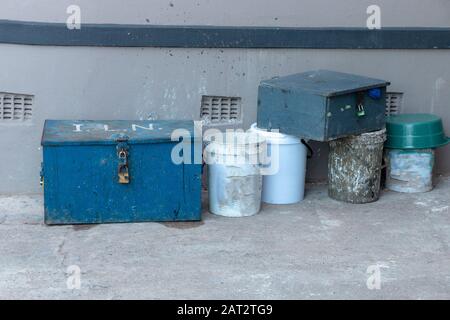 a close up view of a old blue workers box that has locks to keep it closed and conctruction tools Stock Photo