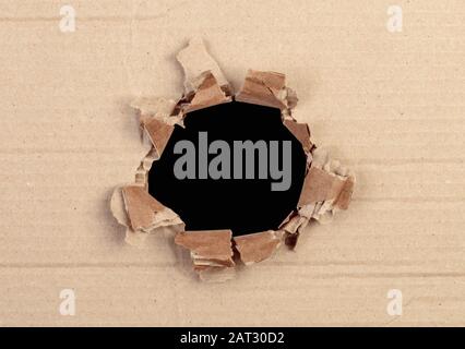 Ripped hole in cardboard package on black background with clipping path Stock Photo