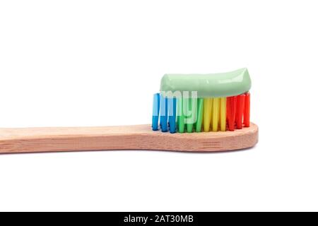 Bamboo toothbrush with green toothpaste macro isolated on white. Eco friendly concept Stock Photo