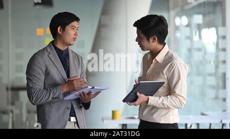 Photo of young business consulting man while talking/giving an advice to customer. Stock Photo