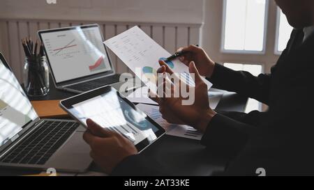 Business development team are discussing/explaining about them business new project with the graphic chart,laptop,tablet and document file at the mode Stock Photo