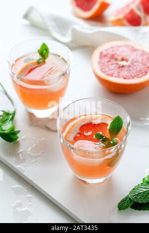 Healthy grapefruit drink with mint on a white marble tray Stock Photo