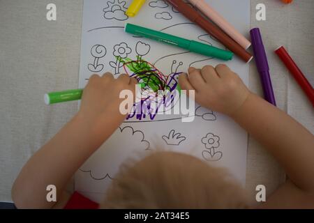 Small child drawing with colored pens - colorful snail scribble Stock Photo