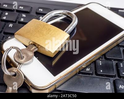 Padlock on keyboard with smartphone Stock Photo