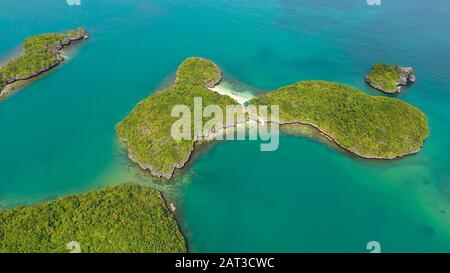 Seascape with a cluster of tropical Islands in turquoise water, aerial seascape. Hundred Islands National Park, Pangasinan, Philippines. Famous tourist attraction, Alaminos. Summer and travel vacation concept