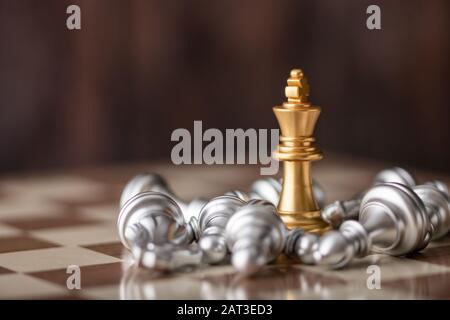 gold king standing in the midst of falling chess on board Stock Photo