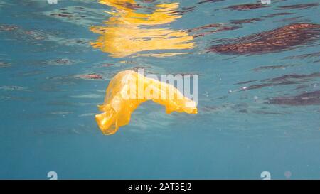 Plastic bag floating in clear water in the sea. Ecological problem. Stock Photo