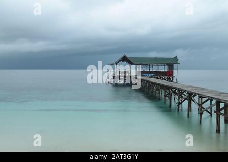 Wooden jetty on a tropical island with cloudy sky.Raja Ampat, West Papua, Indonesia Stock Photo