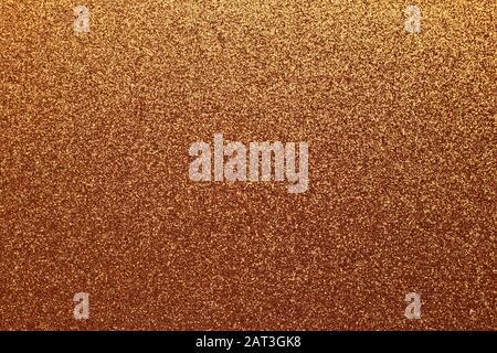 Golden shiny background, yellow sparkles, brown grainy texture. Material pattern, metallic tinsel, decoration Stock Photo