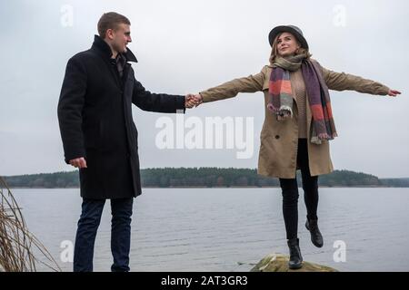 Joyful young couple in winter on a shore of a lake Stock Photo
