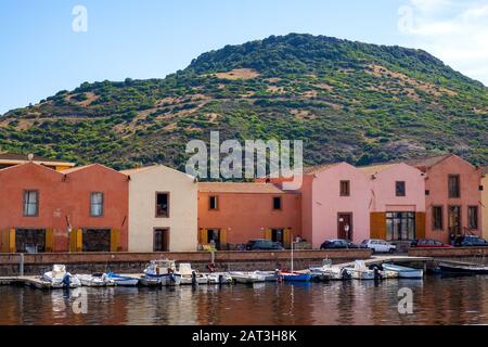 Bosa, Sardinia / Italy - 2018/08/13: Panoramic view of the old town quarter of Bosa by the Temo river embankment with colorful tenement houses and boats Stock Photo