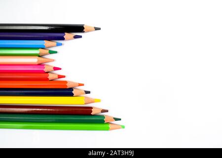 bunch of different colored pencil crayons isolated on a white background while making a beautiful wave Stock Photo