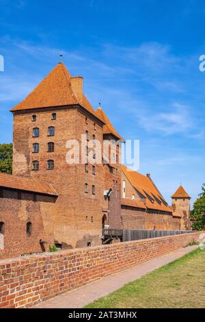 Malbork, Pomerania / Poland - 2019/08/24: Panoramic view of the medieval Teutonic Order Castle in Malbork, Poland - external defense walls with main gate tower and drawbridge over the moat Stock Photo