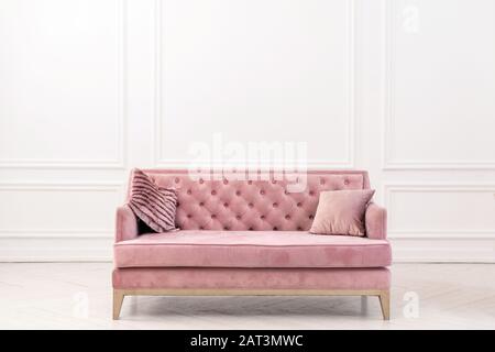 Modern living-room minimalistic  interior with pink sofa near empty white wall. - Image Stock Photo