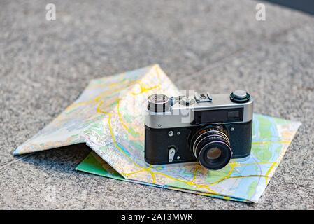 Vintage old camera on a background of old map lying on the stone  - Image Stock Photo