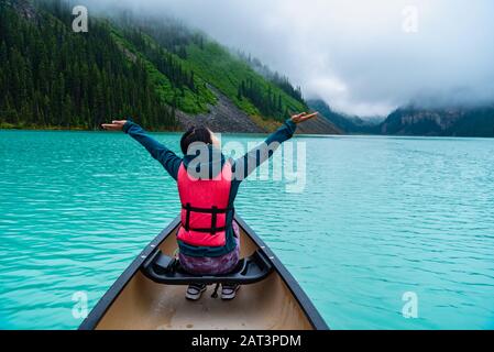 Woman enjoying the view of Lake Louise from Canoe Stock Photo