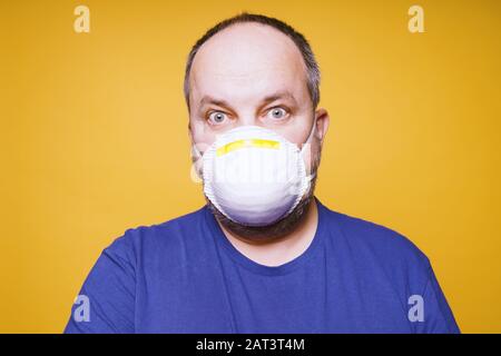 man with face mask and panic in his eyes - corona virus outbreak hysteria concept Stock Photo