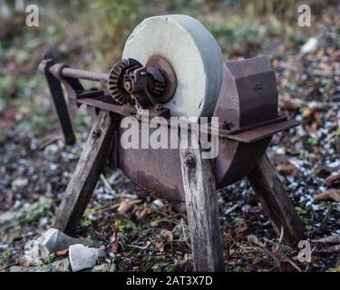 Sharpening knife on old grindstone wheel Stock Photo - Alamy