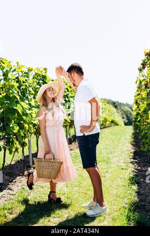Beautiful young couple dancing in the vineyard on sunny day Stock Photo