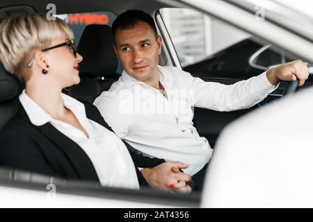 Couple  sitting inside a car  salon and looking tender each other .- Image Stock Photo