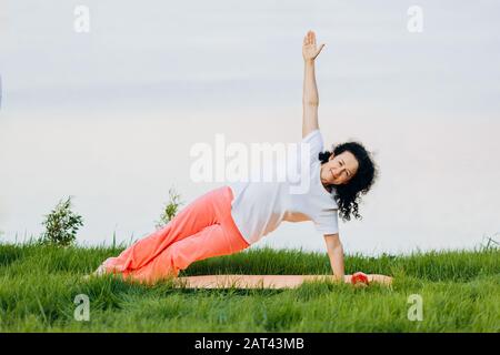 Senior  woman doing yoga asana side plank  outdoor. .- Concept yoga- Image Stock Photo