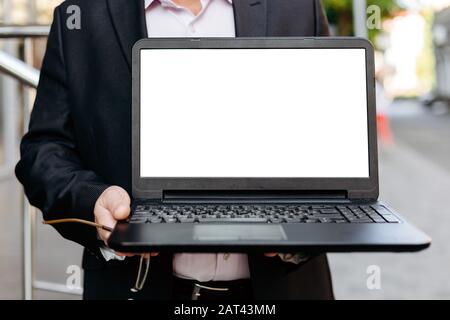 Cropping image of businessman holding open laptop, empty white blank screen- Image Stock Photo