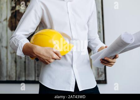 Builder in a helmet with drawings, construction company Stock Photo