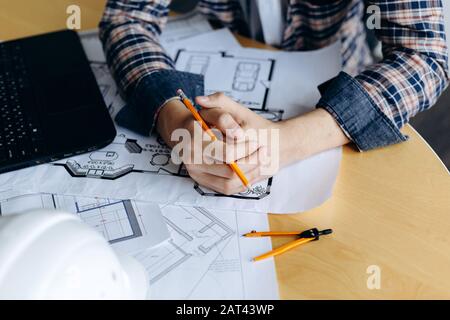 Young creative male engineer working with new project on drawing Stock Photo