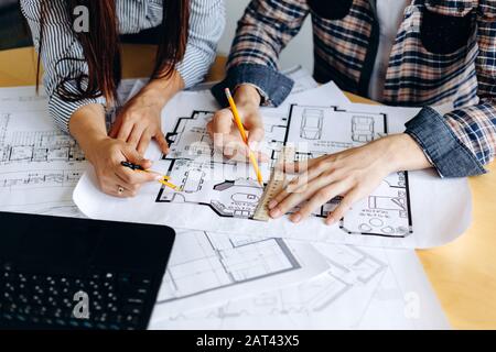 Two serious architects looking at blueprints on a table in the office Stock Photo