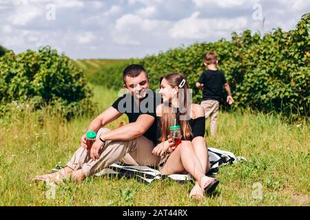 Mother and father having a picnic, smiling and looking each other.- Image Stock Photo