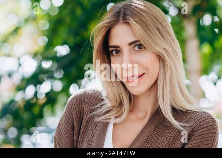 Portrait of a smiling blonde woman looking playfully  at the camera closeup Stock Photo