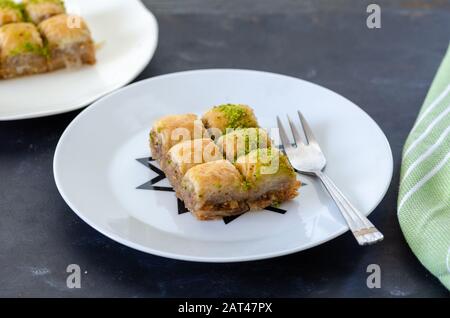 Turkish baklava with walnuts and pistachio on the white plate. Stock Photo