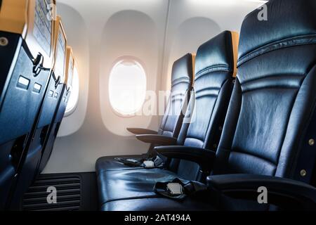 Plane interior - cabin with modern leather chair for passenger of airplane. Aircraft seats and window. - Horizontal image Stock Photo