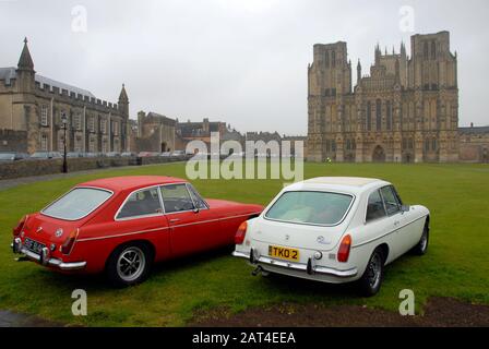 Two MG sports cars parked on grass in front of Wells cathedral Stock Photo