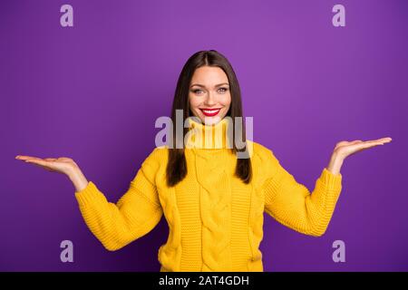 Photo of cheerful positive cute attractive woman holding two things with hands smile toothy holding empty space isolated vivid color background purple Stock Photo