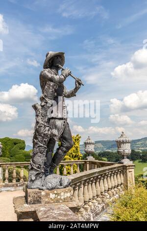 18th century statue of man playing flute with dog, Powis Castle, Powys, Wales, UK Stock Photo