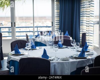 Fold round table with blue napkins in the restaurant Stock Photo