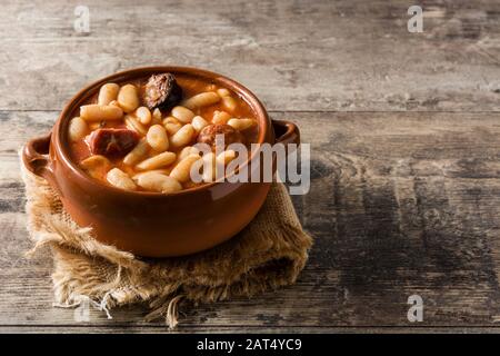Typical Spanish fabada asturiana on wooden table Stock Photo