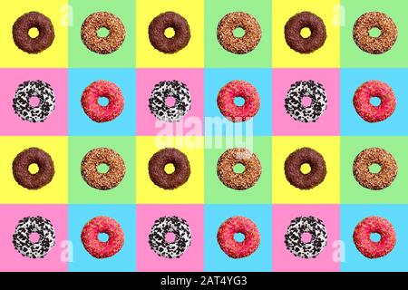 Seamless pattern of different donuts on bright checkered multi-colored background top view, tasty round doughnuts on chequered backdrop, wallpaper Stock Photo