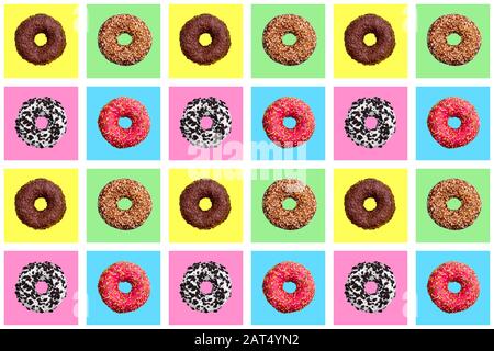 Seamless pattern of different donuts on bright checkered multi-colored background top view, tasty round doughnuts on chequered backdrop, wallpaper Stock Photo