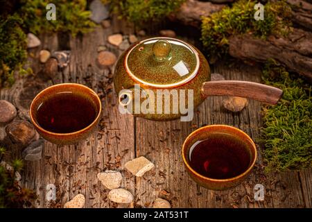 Traditional Asian tea ceremony arrangement. Teapot and cups on wooden table background Stock Photo