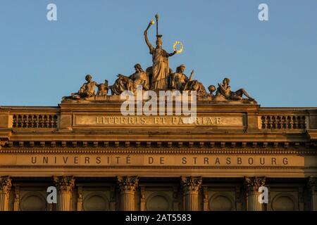 University of Strasbourg main historic building facade at dusk with roman motto and stone statue of Athena greek goddess, Unesco World Heritage, Stras Stock Photo