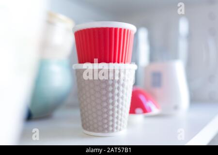 Beautiful shot of two white and pink cups on a shelf in the kitchen Stock Photo