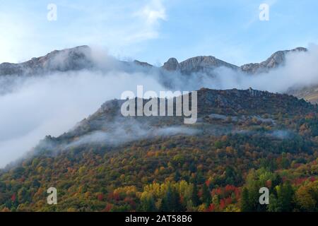 Fog revealing Ligurian Alps mountain range, Piedmont region, Province of Cuneo, north-western Italy Stock Photo