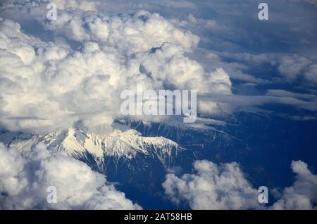 High cloud formations on snow-capped mountains Stock Photo