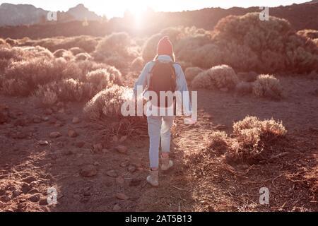 Landscape view on a beautiful volcanic valley with woman hiking on a sunset. Traveling on Teide national park on Tenerife island, Spain