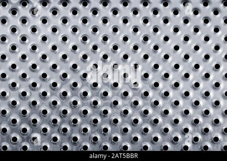 Silver colored metal background with holes. Stock Photo