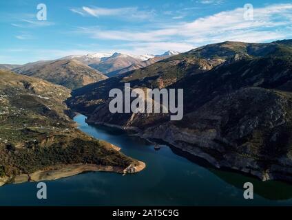 Aerial photography rocky snow-capped Sierra Nevada mountains Embalse de Canales Reservoir in Guejar Sierra, province of Granada, Andalusia, Spain Stock Photo